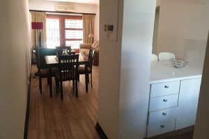 The entrance, kitchen and lounge in the Sandton Gateway self-catering apartment in Craighall Park, Johannesburg.