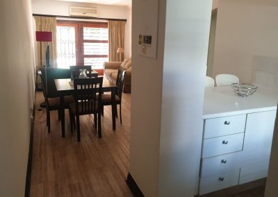 The entrance, kitchen and lounge in the Sandton Gateway self-catering apartment in Craighall Park, Johannesburg.
