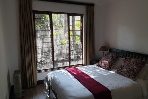 The master bedroom that looks out onto a private, shaded garden in the Sandton Gateway self-catering apartment in Craighall Park, Johannesburg.