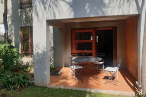 The verandah and lounge from the private garden in the Sandton Gateway self-catering apartment in Craighall Park, Johannesburg.